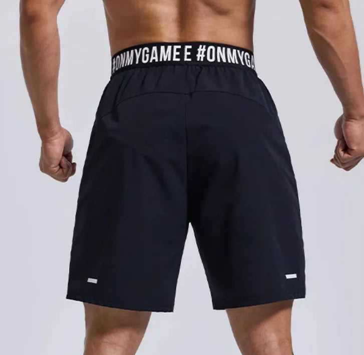 Men's loose black sports shorts with elastic waist and letter detail, shown front and back.