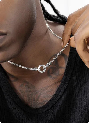 A simple sterling silver clavicle necklace with a small pendant, shown on a model.