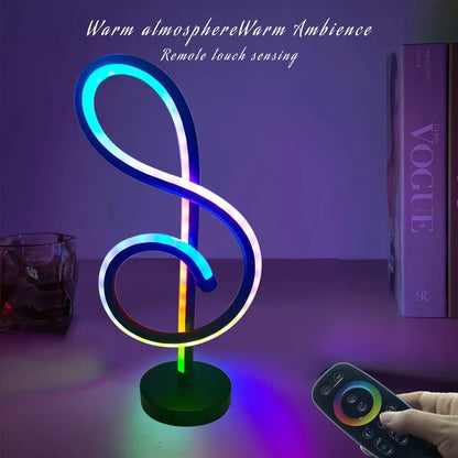 Black remote-controlled LED night light with Bluetooth remote on a bedside table.