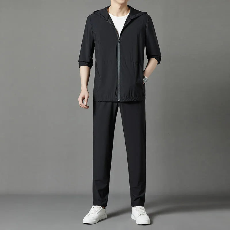 Grey hooded sun-protective top and loose pants suit for men on a hanger.