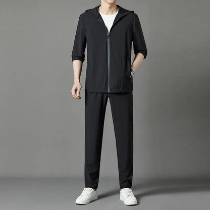 Grey hooded sun-protective top and loose pants suit for men on a hanger.