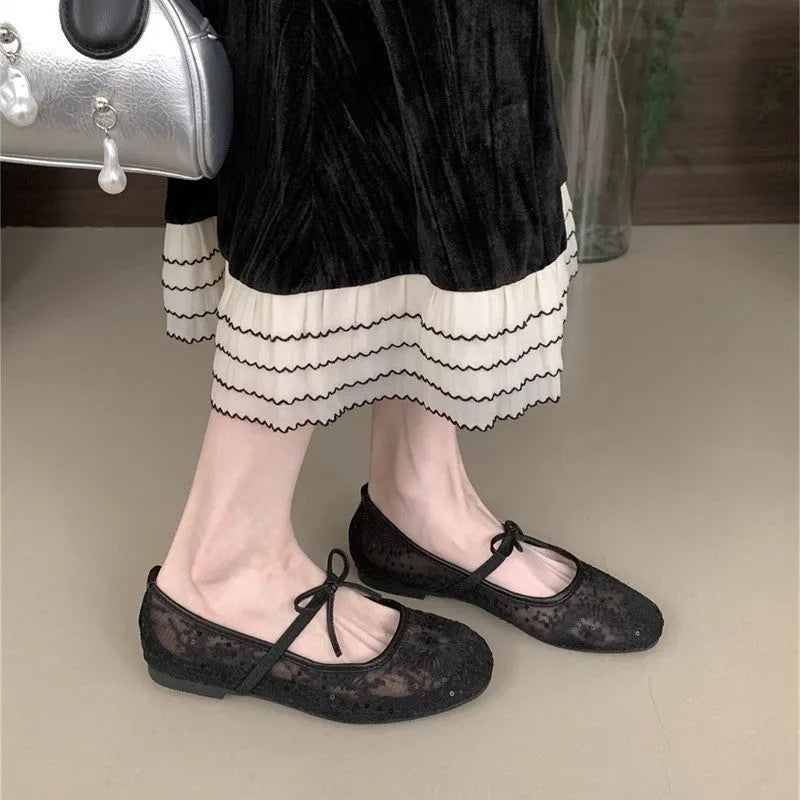 Pink Mary Jane evening shoes with flat lace, mesh upper, and a mid heel on a rubber sole.