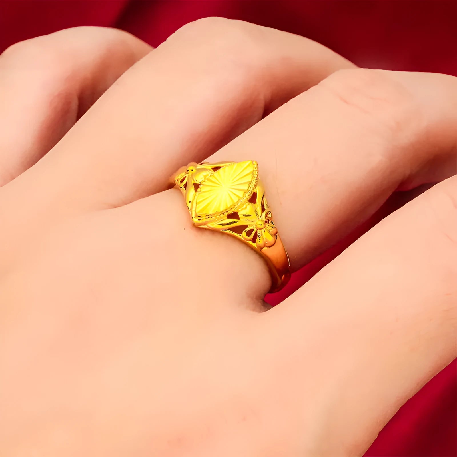 Geometric gold brass ring with open floral cut-out design and textured band, shown from the side.