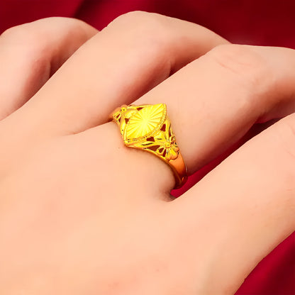 Geometric gold brass ring with open floral cut-out design and textured band, shown from the side.