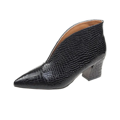 Women's black V cut Martin boots with a pointed embossed toe and a chunky heel.