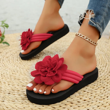 Solid-colour flower flip flops with a decorative floral detail on a viscose upper and EVA sole.