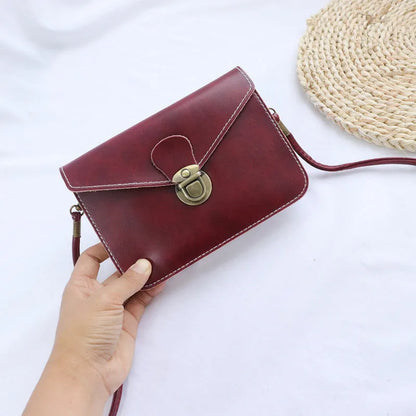 Retro shoulder messenger bag in cross square shape with flap and lock closure, showing internal mobile phone compartment