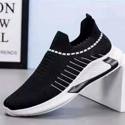 Men's black and white striped slip-on sneakers with lace-up front and mesh upper.