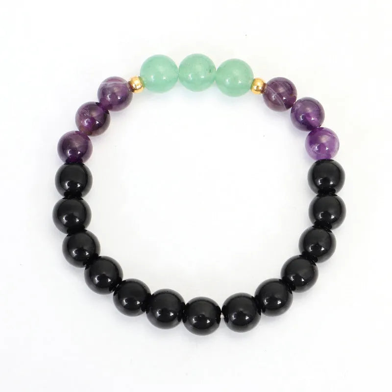 Long stone bead necklace with alloy lotus pendant and matching bracelet set on a background.