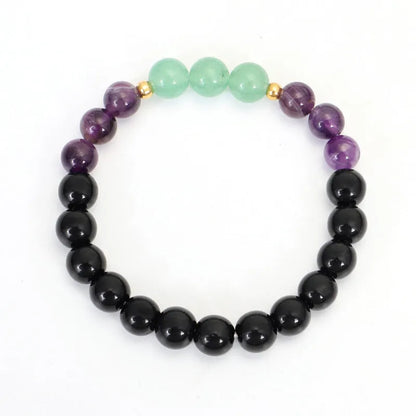 Long stone bead necklace with alloy lotus pendant and matching bracelet set on a background.
