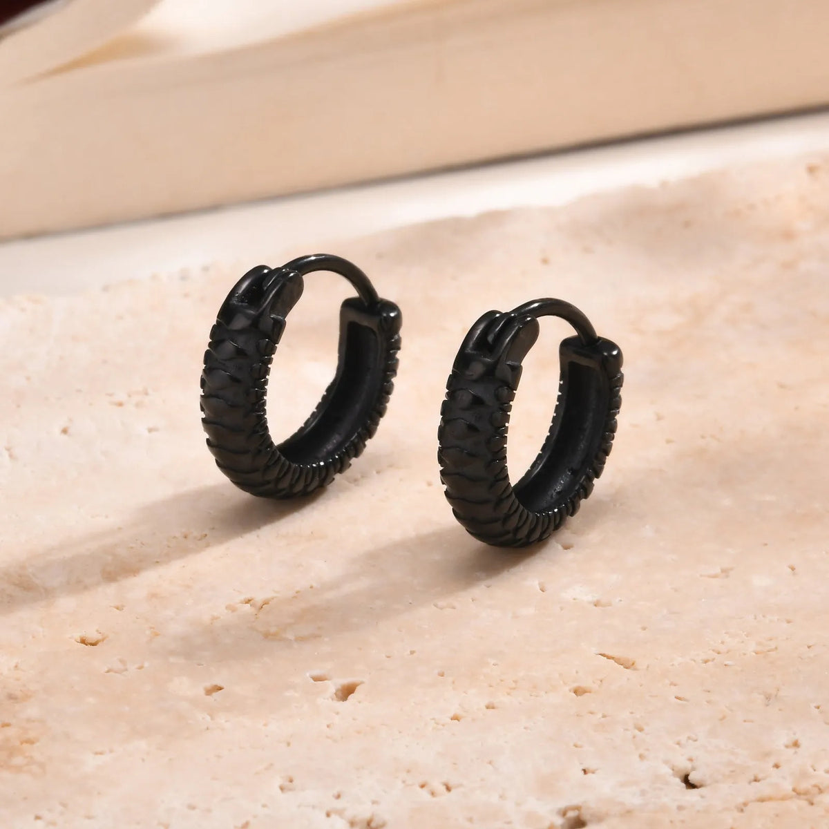 Stainless steel snake pattern earrings in black or gold finish showing textured design