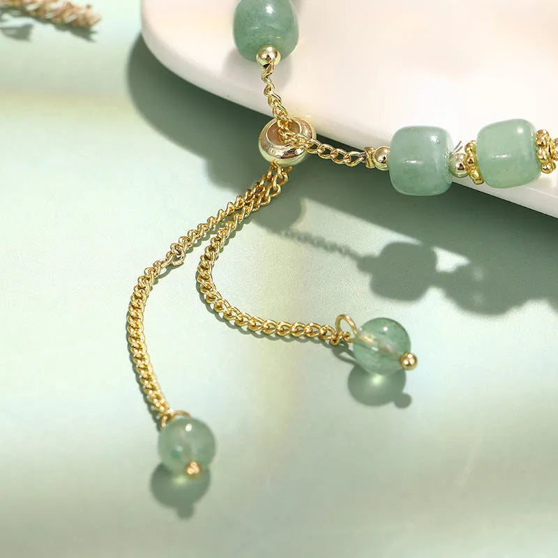 Adjustable rabbit charm bracelet with natural stone beads and gold plated details on a wrist.