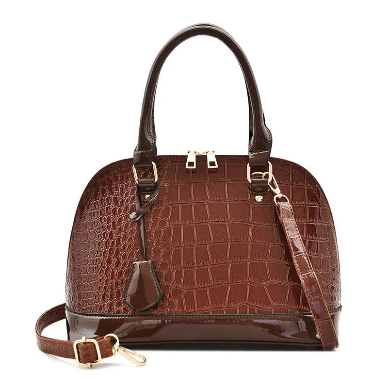 Large shiny black PU leather crossbody bag with a shell shape, shown from the front.