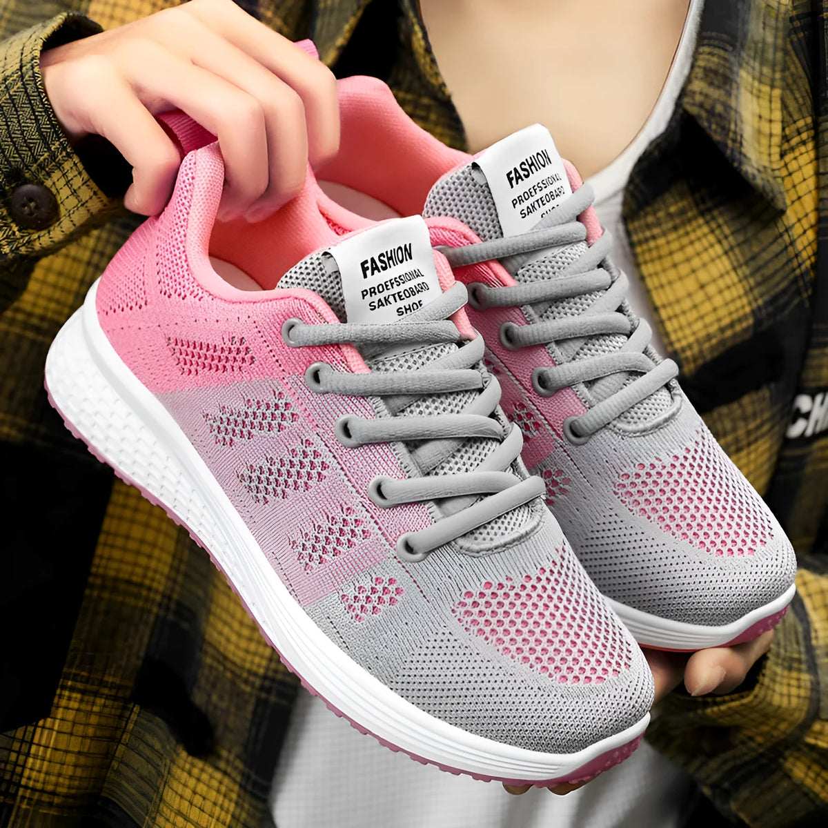 Women's flyknit running shoes in grey pink with soft sole and lace-up front.