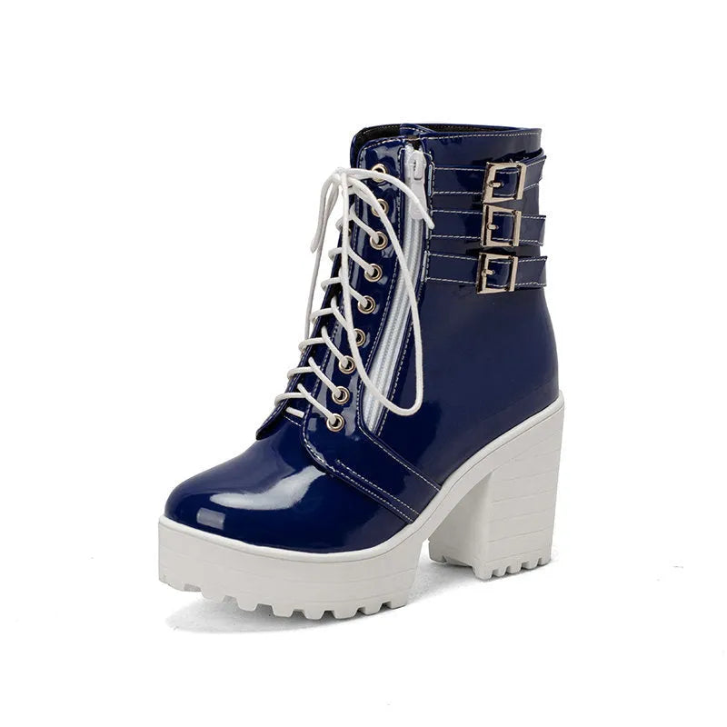 Women's black chunky heel ankle boots with round toe and front lace-up on a wooden floor.