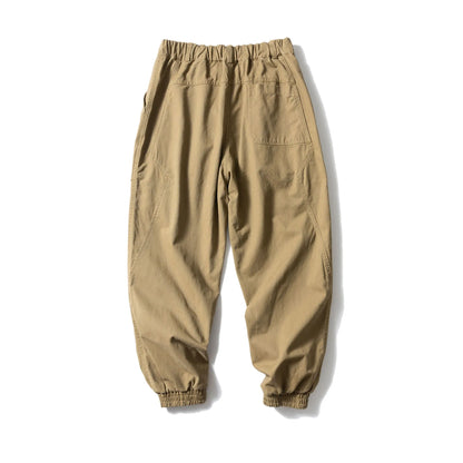 Solid colour cotton casual pants with large pockets and a tapered, ankle-tied silhouette.