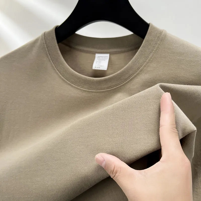 Men's thin cotton drop shoulder t-shirt on a hanger, shown in a light colour.