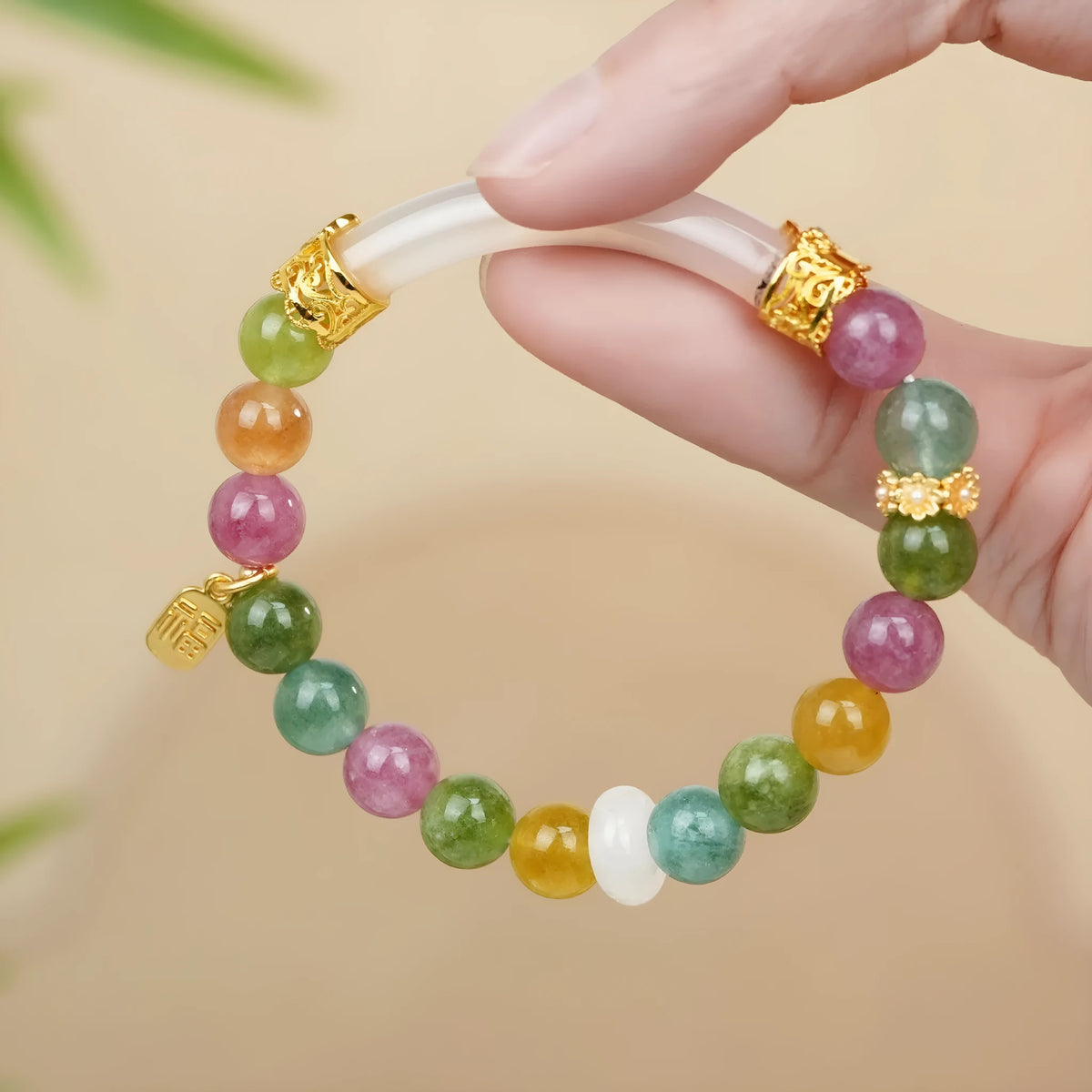 Rainbow-coloured tourmaline half bracelet for women on a wrist.