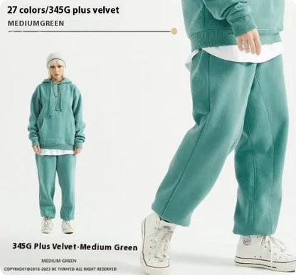 Man wearing solid colour cotton velvet sweatpants with an ankle banded design in a dark grey shade.