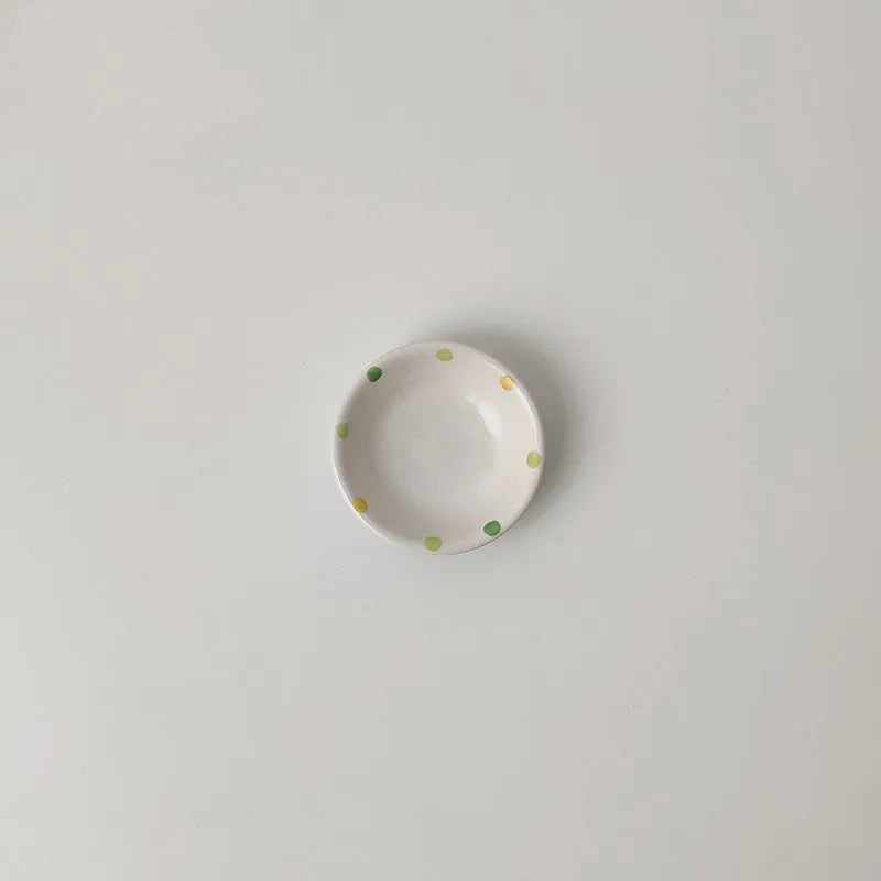 Japanese-style dot pattern porcelain plates and bowls in irregular oval and round shapes on a table.