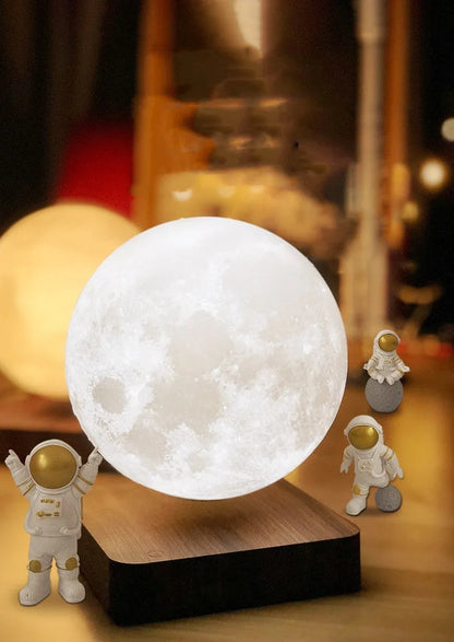 Maglev floating moon planet atmosphere night light with three astronaut figurines on a desk.