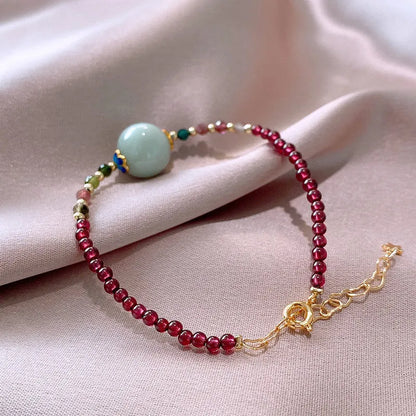 Women's garnet bracelet with aquamarine tourmaline drop charm and electroplated finish