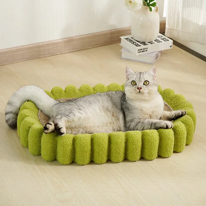 Green oval sisal cat scratching pad and lounge bed on a wooden floor.