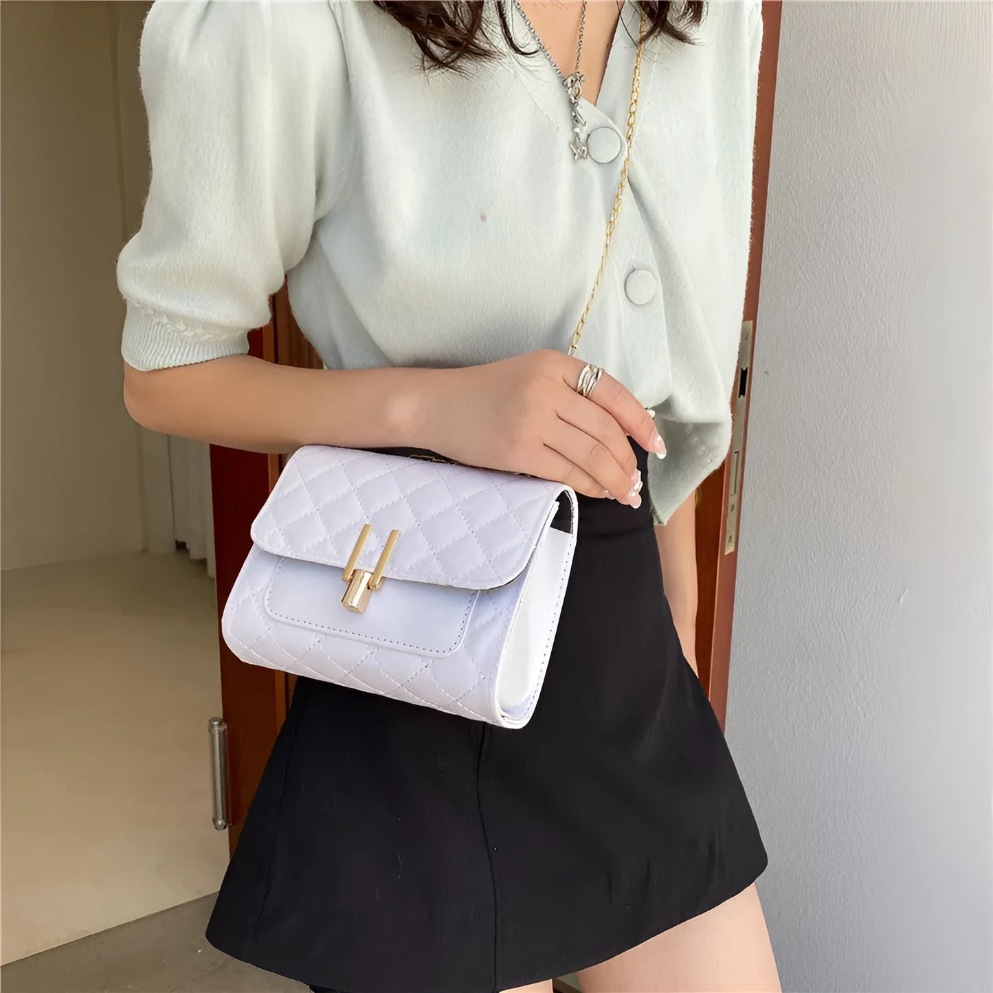 Minimalist women's crossbody bag in vegan PU leather with a diamond lattice chain strap.