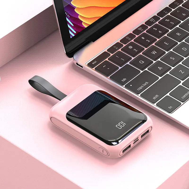 White portable power bank with 20000mAh capacity and multiple USB output ports on a table.