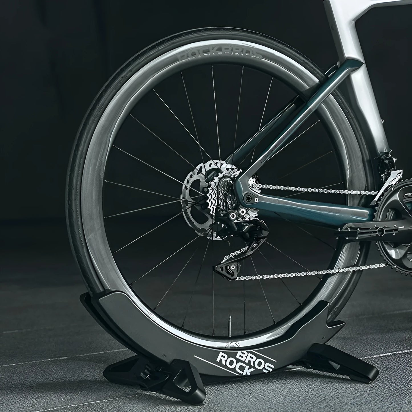 A black wall-mounted ABS plastic bracket holding a mountain bike vertically for storage.