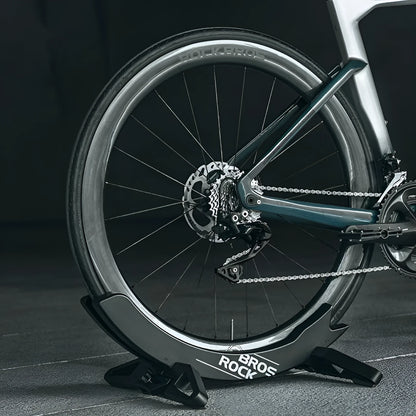 A black wall-mounted ABS plastic bracket holding a mountain bike vertically for storage.