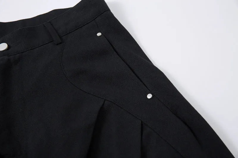 Men's black cotton pleated casual trousers with a loose-fitting wide-leg silhouette.