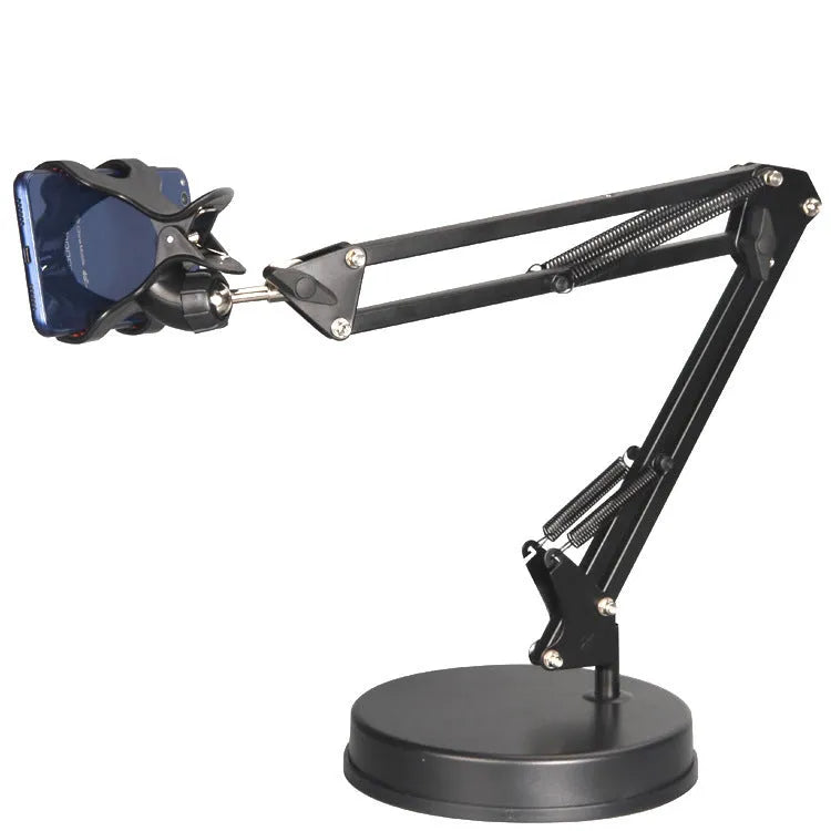 Black metal adjustable phone and tablet stand with a heavy round base on a wooden desk
