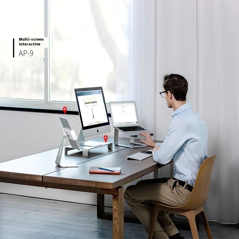 Black aluminium alloy laptop stand on a desk, showing its raised platform and open base design.