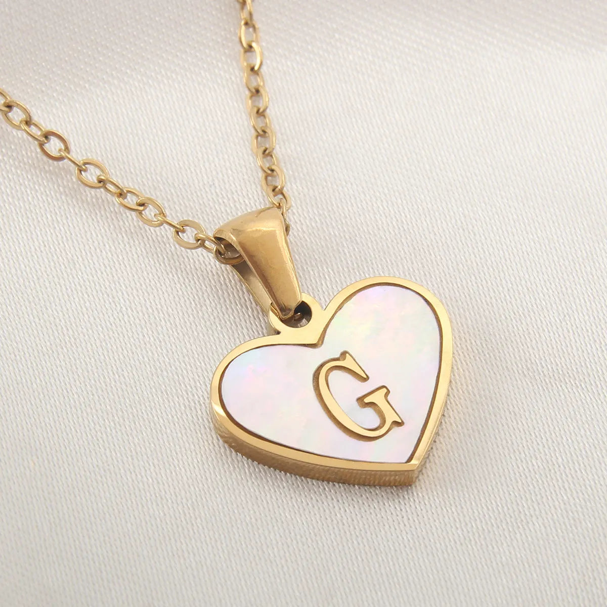 Gold-plated heart necklace with white shell pendant showing letter personalisation option