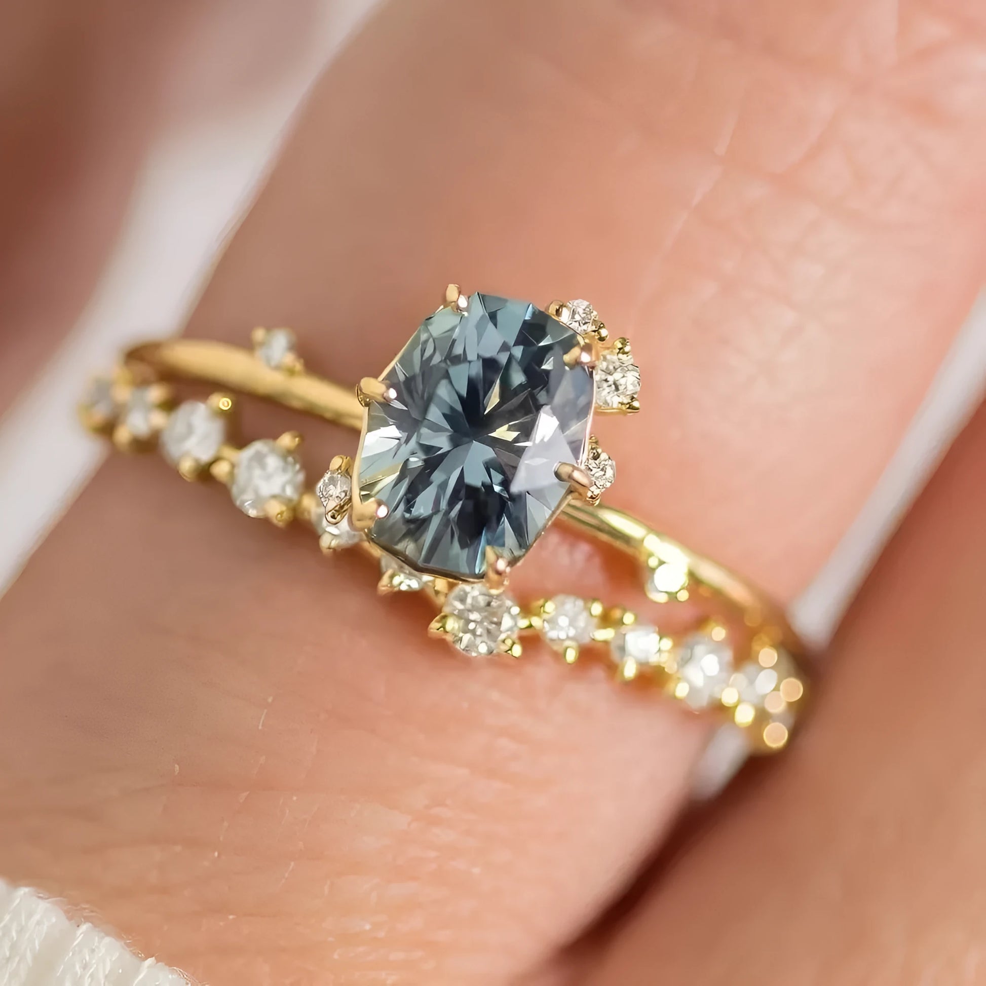 Gold-plated floral women's ring with a green zircon stone centrepiece on a model's hand.