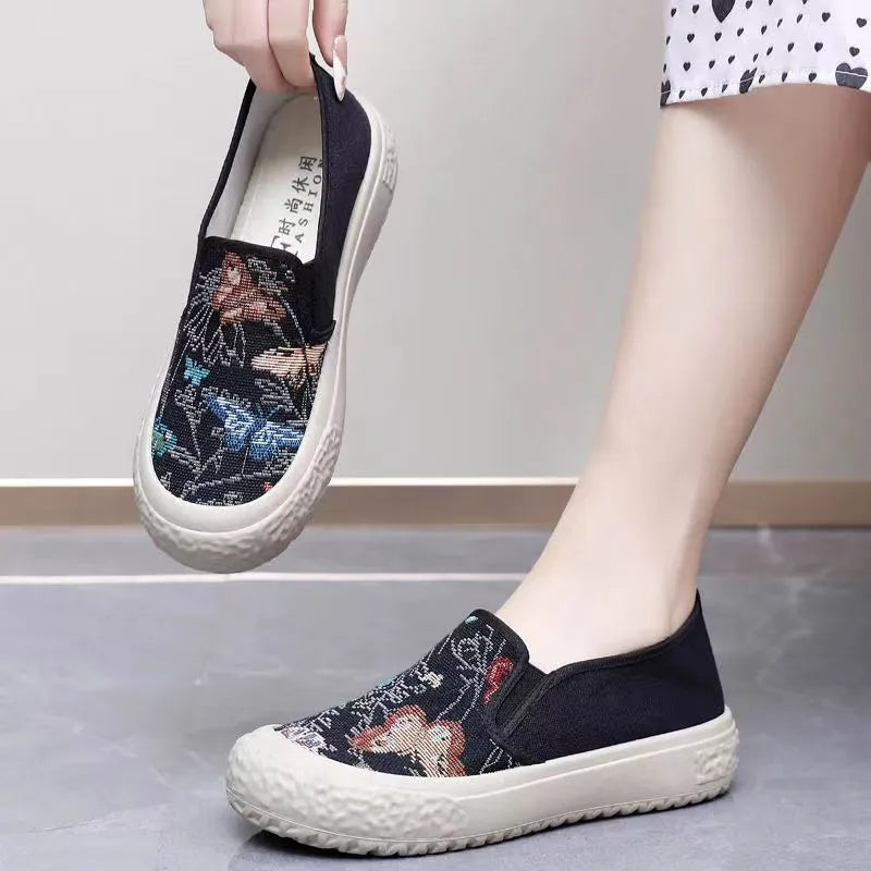 Women's black and white slip-on canvas shoes with round toe and decorative stitching