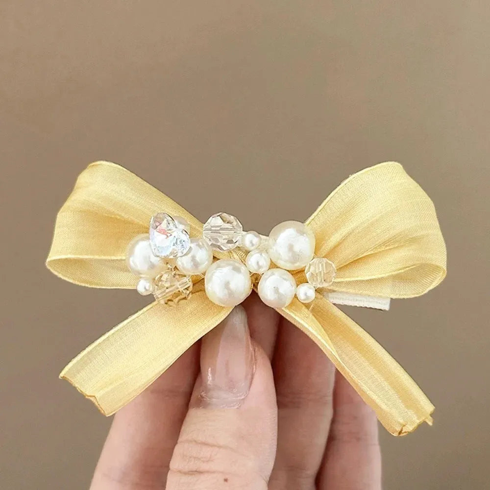 Yellow bow barrette hair clip with rhinestone pearls and duckbill clip mechanism