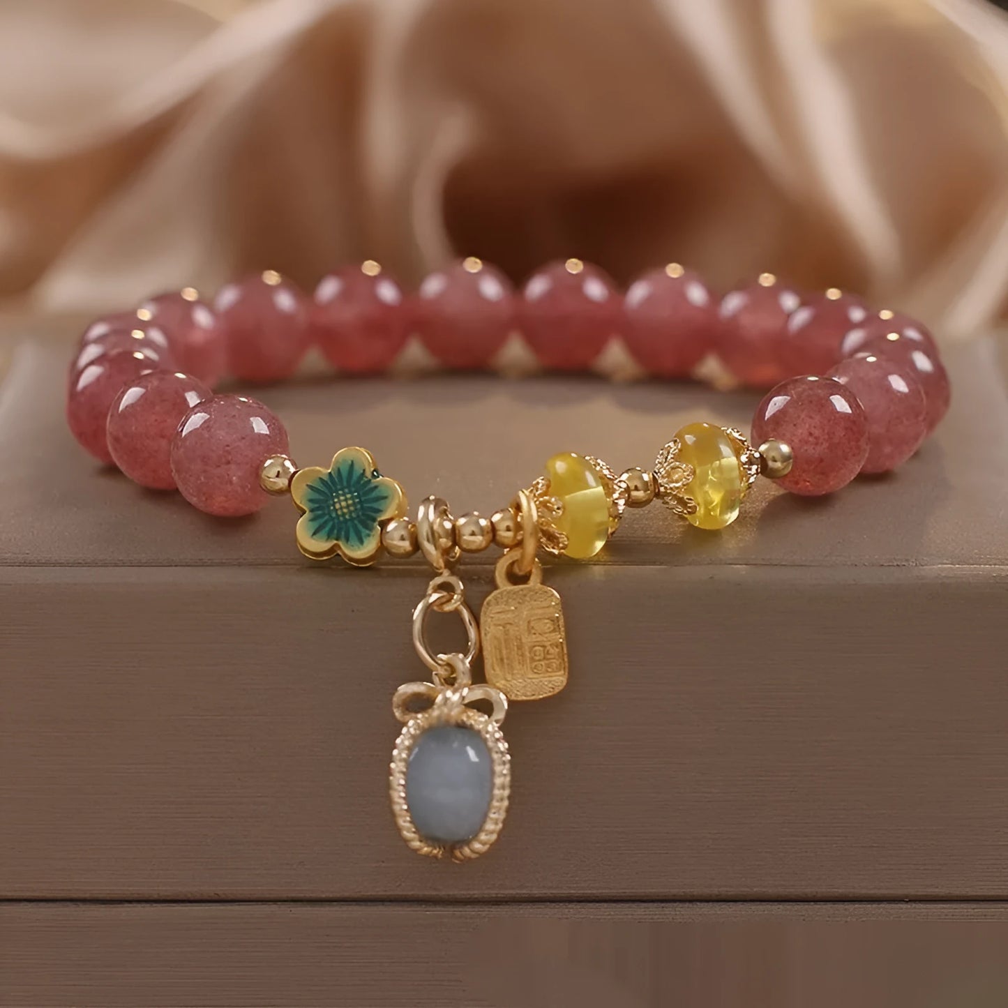 Red beaded bracelet with strawberry quartz gems, alloy clasp, and rhinestone details.