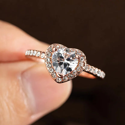 Women's heart-shaped crystal ring in rose gold or silver tone on white copper.