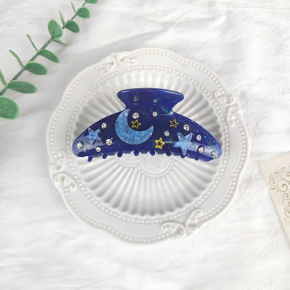 Oversized star barrettes in starry sky colours showing minimalist design and irregular elements