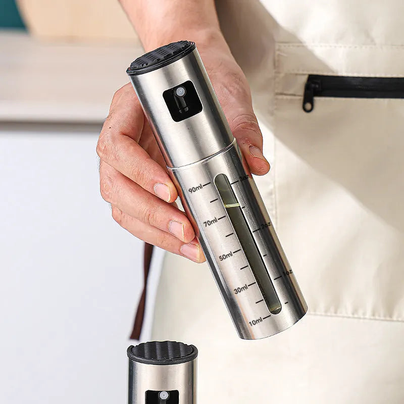 Glass oil spray bottle with stainless steel press cap showing 100ml capacity