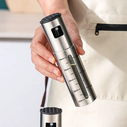 Glass oil spray bottle with stainless steel press cap showing 100ml capacity