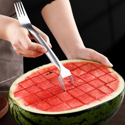 Stainless steel watermelon slicer and serving fork on a kitchen counter.