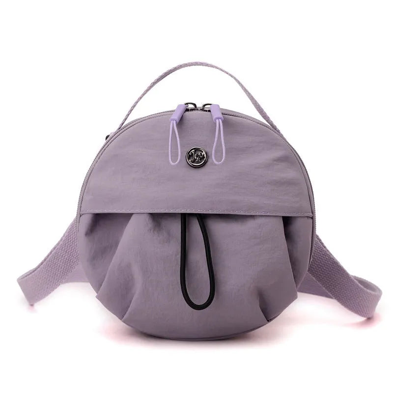 Out shoulder crossbody messenger bag in nylon showing interior zipped changing bag, phone pocket, and document compartment.