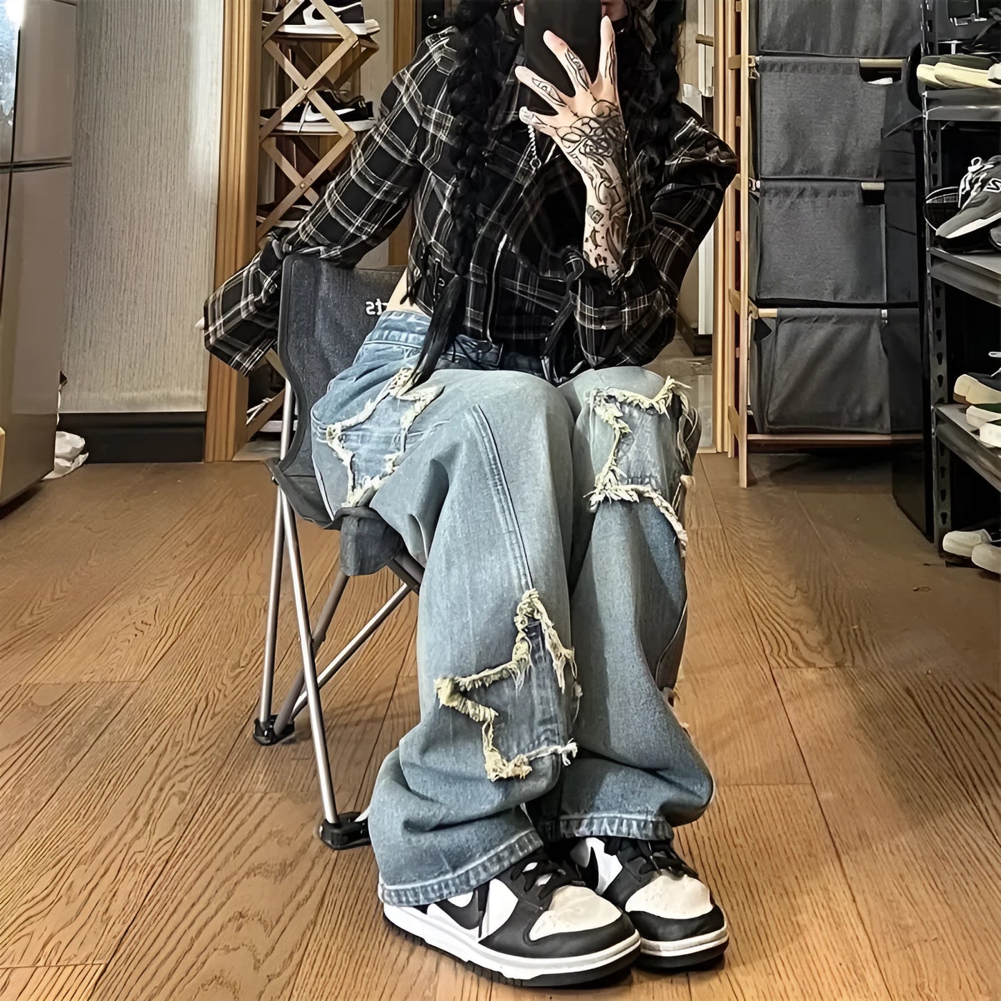 Blue high-waisted wide-leg denim trousers with a straight-leg cut on a model.