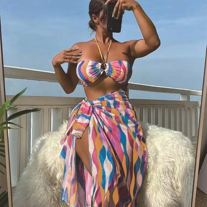 Women's three-piece swimwear set showing bikini top, briefs and printed beach skirt in polyester fabric