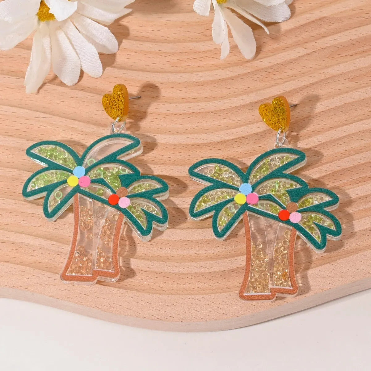 A pair of colourful acrylic earrings shaped like a strawberry and a cherry on a woman's ear.