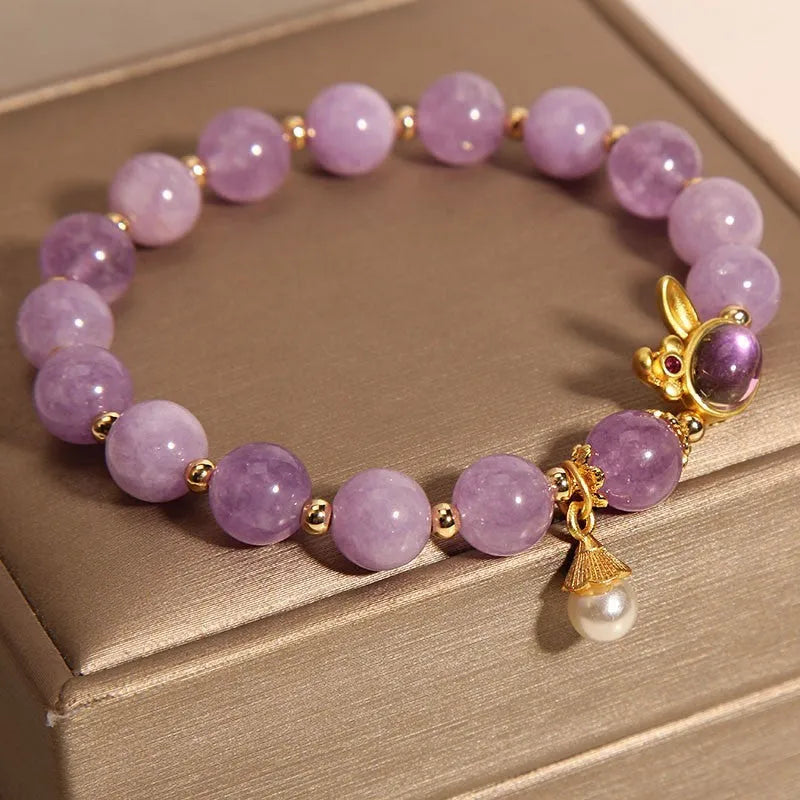 Natural mauve jade rabbit head charm bracelet with crystal details on wrist.