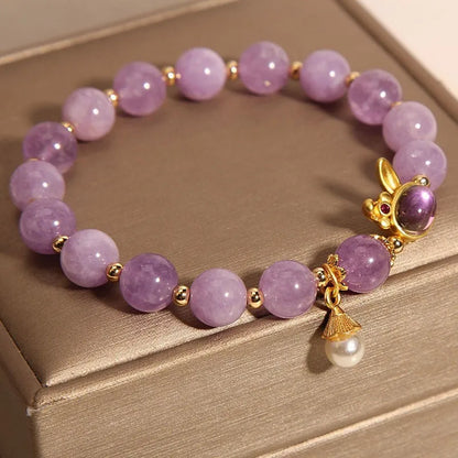 Natural mauve jade rabbit head charm bracelet with crystal details on wrist.